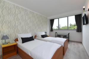 una camera d'albergo con due letti e una finestra di Hotel Tolero a Ploče (Porto Tolero)