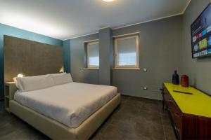 um quarto com uma cama e uma televisão em CityU - Milano 25 Appartamento Trento Centro con parcheggio privato em Trento