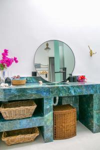 a bathroom with a blue sink and a mirror at Seabed Suites Mykonos in Mikonos