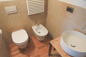 bagno con servizi igienici bianchi e lavandino di Visaisa taverna & foresteria ad Acceglio
