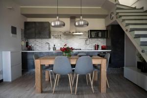 a kitchen with a wooden table and blue chairs at Ritratto di Donna in Lerici