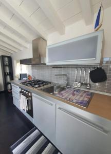 a kitchen with a sink and a stove at La casa di Elena Versilia - Two Apartments in Marina di Pietrasanta