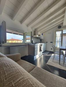 a living room with a couch and a table and a kitchen at La casa di Elena Versilia - Two Apartments in Marina di Pietrasanta