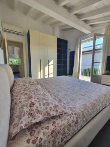 a bedroom with a large bed with a floral bedspread at La casa di Elena Versilia - Two Apartments in Marina di Pietrasanta