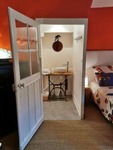 um pequeno quarto com uma mesa e uma porta em Chambre aux coccinelles em Cosne-Cours-sur-Loire