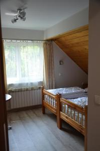 um quarto com uma cama de madeira e uma janela em Magurka Rycerka Górna em Rycerka Górna
