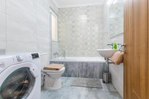 y baño con lavadora y lavamanos. en Brand New Apartment 3 Bdr 2 Bth Bugibba B8, en St Paul's Bay