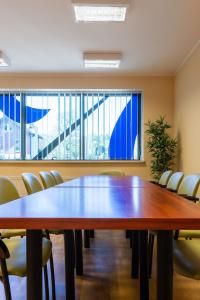 une salle de conférence avec une grande table et des chaises en bois dans l'établissement Gdańska Szkoła Szermierki, à Gdańsk