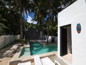 una piscina con sillas blancas y palmeras en Quiet and peaceful house, all installations are private, with pool and very close to the beach, en Telchac Puerto