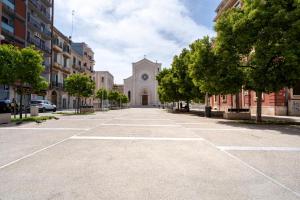 uma rua vazia em frente a uma igreja com árvores em La Bombetta Cheerful Apartment em Bari