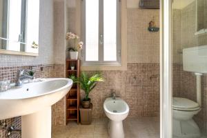 uma casa de banho com um lavatório e um WC em La Bombetta Cheerful Apartment em Bari