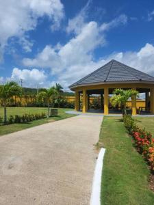 uma passagem que leva a um pavilhão num parque em Stonebrook Villa em Falmouth