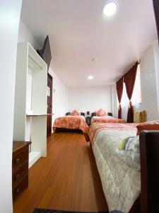 1 dormitorio con 2 camas y vestidor en Hostal La Terraza, en Quito