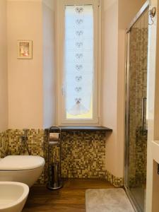 łazienka z toaletą, umywalką i oknem w obiekcie Il posto giusto w mieście La Spezia