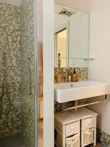 W łazience znajduje się umywalka, lustro i prysznic. w obiekcie Il posto giusto w mieście La Spezia