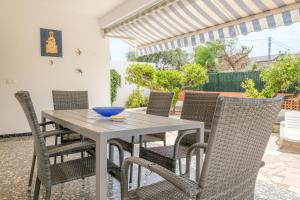 une table blanche et des chaises sur une terrasse dans l'établissement Can Quetu, à Vinaròs