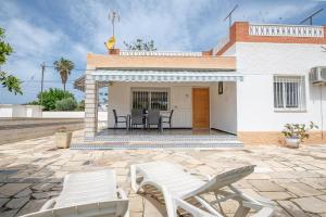une terrasse avec 2 chaises blanches et une maison dans l'établissement Can Quetu, à Vinaròs