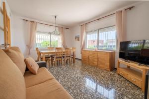 un salon avec un canapé, une télévision et une table dans l'établissement Can Quetu, à Vinaròs