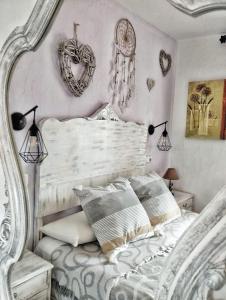 Un dormitorio con una cama blanca con corazones en la pared en Cala Moraig, en Benitachell