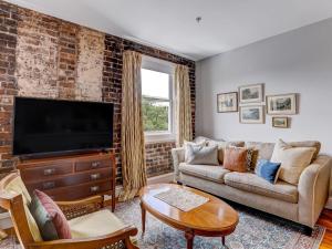 a living room with a brick wall at Above Broughton St 3002 in Savannah