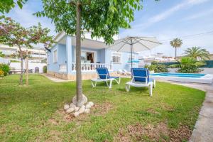 una casa con due sedie e un albero in cortile di Marblau 4 a Vinarós