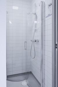 ein Bad mit einer Dusche und einer Glastür in der Unterkunft Gullbrannagården in Halmstad