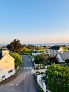 een lege straat in een klein stadje met huizen bij Hôtel L'Orée des plages in Clohars-Carnoët