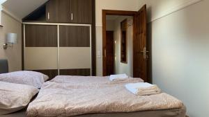 sypialnia z 2 łóżkami i ręcznikami w obiekcie See Haus - Podmaniczky Szállás, Bor, Balaton w Balatonföldvárze