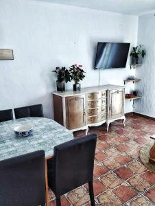 a living room with a table and a flat screen tv at Cala Moraig in Benitachell