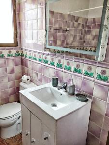 Baño rosa con lavabo y aseo en Cala Moraig, en Benitachell