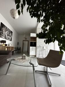 a living room with a chair and a glass table at Apartmán Lodenica in Piešťany
