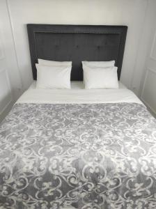 a bed with a black and white comforter and two pillows at Penthouse Las Americas first line de lux in Arona