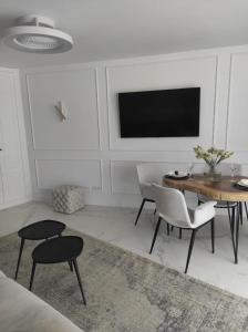 a living room with a table and chairs and a tv at Penthouse Las Americas first line de lux in Arona +20 photos