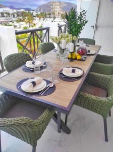 a wooden table with plates of food on a balcony at Penthouse Las Americas first line de lux in Arona