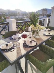 a wooden table with plates and glasses on a balcony at Penthouse Las Americas first line de lux in Arona