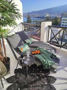 a table on a balcony with a drink on it at Penthouse Las Americas first line de lux in Arona