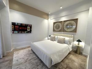 a bedroom with a white bed in a room at AmazINN Places Casco Viejo Jacuzzi, Adults only in Panama City