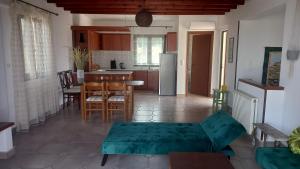 ISLAND HOME في Zipárion: غرفة معيشة مع طاولة ومطبخ