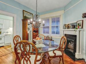 une salle à manger avec une table, des chaises et une cheminée dans l'établissement Victoria's on Lincoln, à Savannah