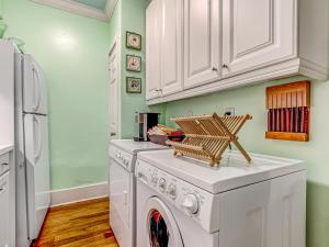 - un lave-linge et un sèche-linge blancs dans une cuisine aux murs verts dans l'établissement Victoria's on Lincoln, à Savannah