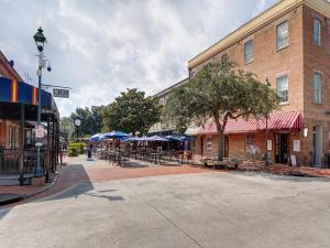 une rue vide dans une ville avec des tables et des parasols dans l'établissement Victoria's on Lincoln, à Savannah
