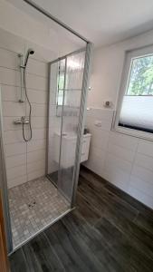 ein Bad mit einer Dusche und einer Glastür in der Unterkunft Tornower Waldhäusl 
