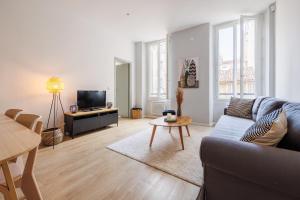ein Wohnzimmer mit einem Sofa und einem TV in der Unterkunft 15 minutes du Vieux Port, Confort et Espace au calme du Palais Longchamp in Marseille