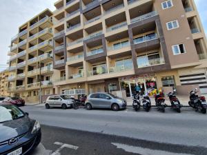 Un grupo de motocicletas estacionadas frente a un edificio. en Brand New Apartment 3 Bdr 2 Bth Bugibba B8, en St Paul's Bay