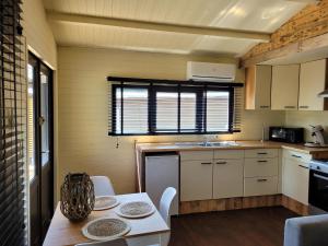 een kleine keuken met een tafel en een wastafel bij Rustig gelegen chalet Solvo met terras aan het water in Geel