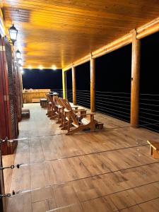 a row of wooden benches on a deck at night at As 3 Casinhas no Paraiso em Cunha!! in Cunha