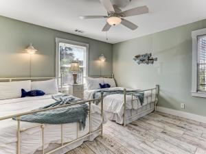 2 camas en una habitación con ventilador de techo en Once Upon a Tide, en Tybee Island