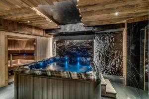 a jacuzzi tub in a room with wooden ceilings at Chalet ANNAPURNA Lodge GANGA 5 étoiles in Tignes