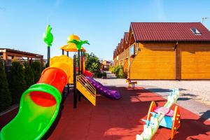 a playground with a slide and a slideintend at Sunrise-Sarbinowo domki i apartamenty in Sarbinowo