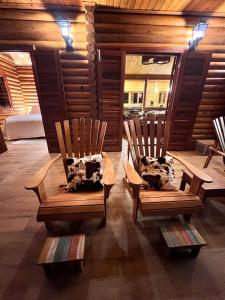 two wooden chairs sitting in a room with a bed at As 3 Casinhas no Paraiso em Cunha!! in Cunha
